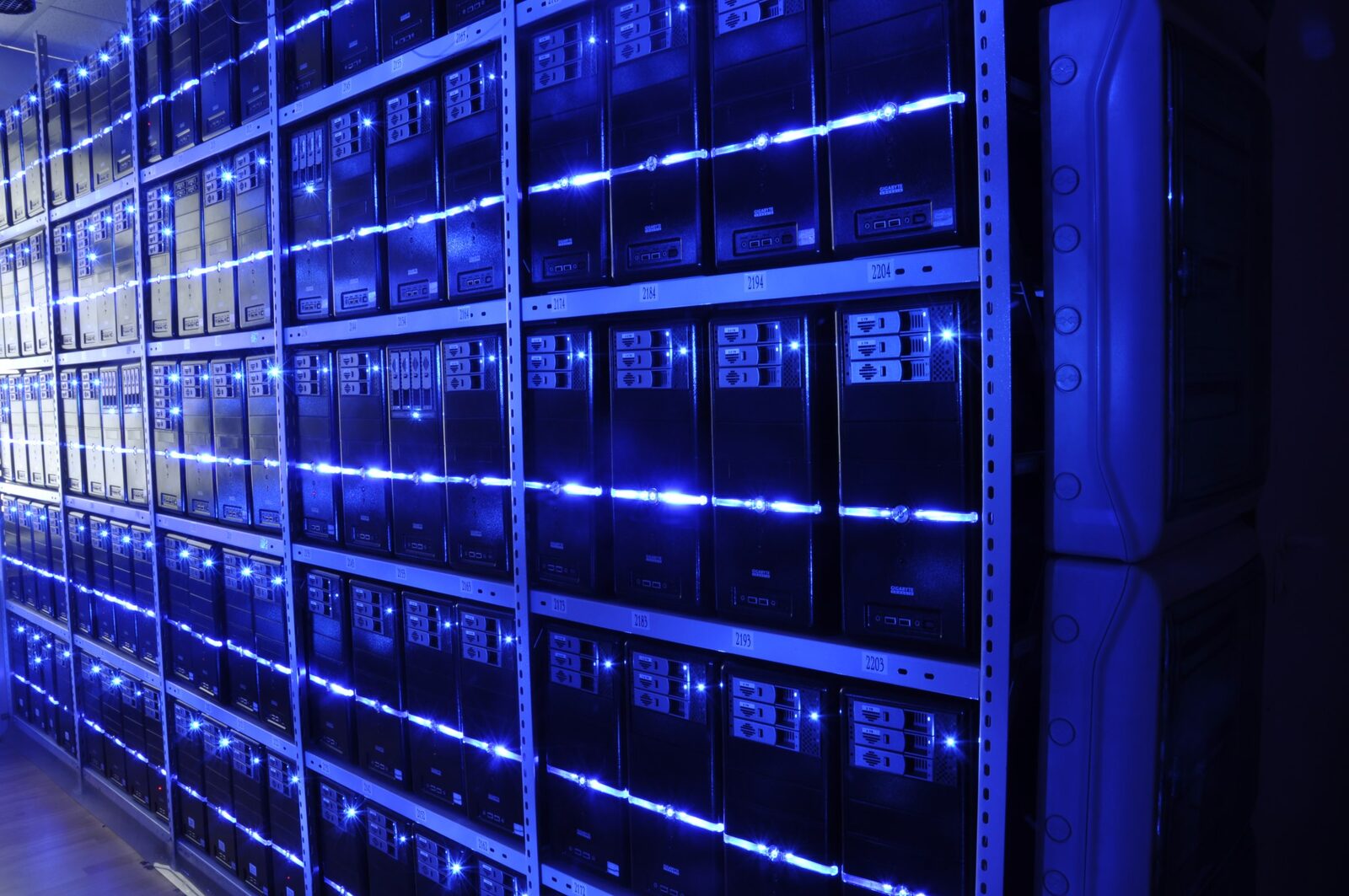 A long aisle of server racks in a data center — the literal location where every chat with an AI companion ends up sitting
